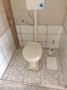 een badkamer met een toilet in een betegelde kamer bij Putuo eco-lodge 