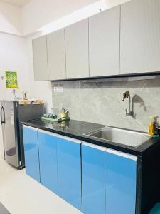 a kitchen with a sink and a refrigerator at BRIJ Homes- 2 Bedroom Premium Apartment in Indore