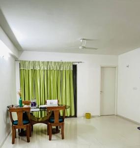 a room with a table and a green curtain at BRIJ Homes- 2 Bedroom Premium Apartment in Indore