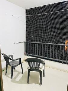 two black chairs sitting in a room at BRIJ Homes- 2 Bedroom Premium Apartment in Indore