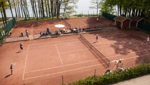 a group of people playing tennis on a tennis court at Villa Eira vandrarhem in Hjo