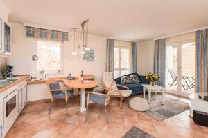 eine Küche und ein Wohnzimmer mit einem Tisch und Stühlen in der Unterkunft Villa Strandperle, App 13 - nur 20m zum Strand, TOPLAGE in Binz