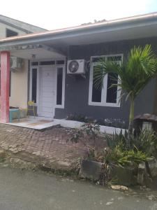 niebieski dom z palmą przed nim w obiekcie Kenangan Guest House w mieście Sabang