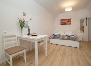 a bedroom with a bed and a table and a desk at Studio apartment JELI in Cavtat