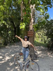 a woman riding a bike in front of a tree at Sawasdee Lagoon Camping Resort in Ban Lam Pi
