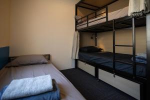 two bunk beds in a room with two beds at Base Camp Hostel in Adelaide