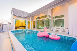 una piscina con dos inflables en una casa en Pandara pool villa cha-am, en Cha Am