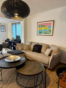 een woonkamer met een bank en tafels bij Les Villas de la Plage in Névez