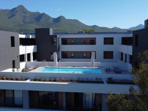 a building with a swimming pool and mountains in the background at 103 Le Jardin in George