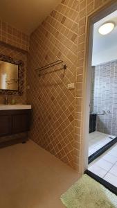 ein Badezimmer mit Dusche, Waschbecken und Spiegel in der Unterkunft 城市角落民宿 in Hualien