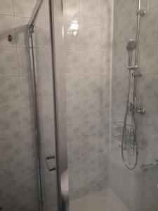 La salle de bains est pourvue d'une douche avec une porte en verre. dans l'établissement Emilka 2, à Suwałki