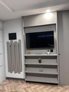 a entertainment center with a flat screen tv on a wall at Room Studio in Tirana