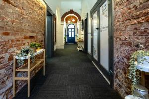 a corridor in a building with a brick wall at Base Camp Hostel in Adelaide