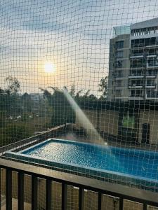 a view of a swimming pool through a fence at BRIJ Homes- 2 Bedroom Premium Apartment in Indore