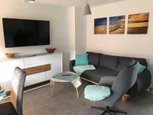 a living room with a couch and a tv at Fewo-Sveike in Neukirchen