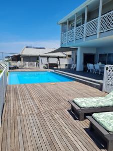 a deck with a swimming pool and a house at Fairview Guesthouse in Ballito