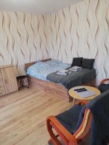 a bedroom with a bed and a table and chairs at Emilka 2 in Suwałki