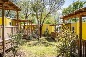 a row of yellow cottages in the woods at Villaggio San Francesco in Duna Verde