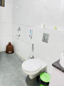 a white bathroom with a toilet and a sink at BRIJ Homes- 2 Bedroom Premium Apartment in Indore