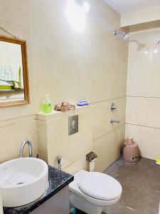 a bathroom with a white toilet and a sink at BRIJ Homes- 2 Bedroom Premium Apartment in Indore