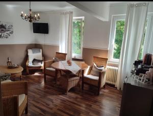 - une salle à manger avec une table, des chaises et des fenêtres dans l'établissement Aparthotel & Wohnungen am Norderteich, à Horn-Bad Meinberg