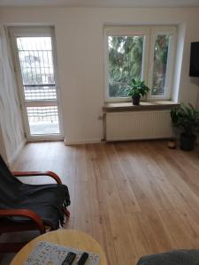 an empty living room with two windows and a table at Emilka 2 in Suwałki
