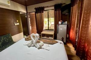 a bedroom with a bed with a towel on it at Huen Pak Mon Chantra in Ban Long O