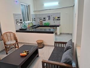a living room with a table and a kitchen at PENTHOUSE APARTMENT in Madurai