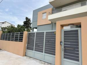 a building with a garage door and a fence at Villa Daniela in Loutraki