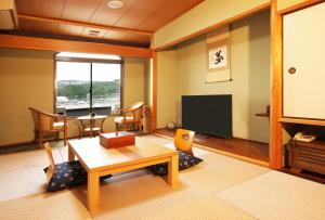 白浜・温泉リゾート海岳 في شيراهاما: غرفة معيشة مع طاولة وتلفزيون