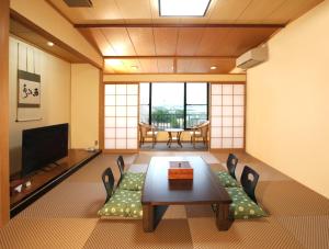 白浜・温泉リゾート海岳 في شيراهاما: غرفة معيشة مع طاولة وكراسي