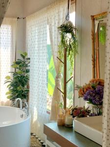 a bathroom with a tub and a sink and a mirror at กลิ่นไอทุ่งโฮมสเตย์ in Ban Thum