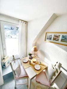 ein Esszimmer mit einem Tisch, Stühlen und einem Fenster in der Unterkunft Apartment Rose in Forbach