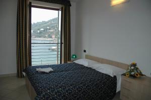 a bedroom with a bed and a large window at Hotel Residence Le Terrazze in Portovenere