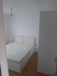 1 dormitorio con 1 cama blanca en una habitación en King srl, en Craiova