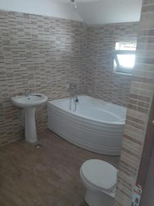 a bathroom with a tub and a toilet and a sink at King srl in Craiova