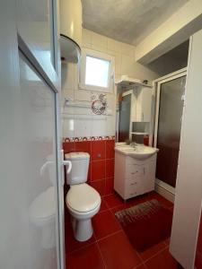 a small bathroom with a toilet and a sink at Guest House Perazić in Bar