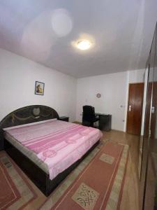 a bedroom with a large bed with a pink blanket at Guest House Perazić in Bar