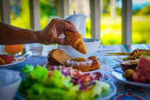 a person holding a piece of bread over a table of food at Dusit Thani Krabi Beach Resort - SHA Extra Plus in Klong Muang Beach