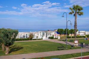 a park with a bench and a palm tree at Vintage al Mare_ fronte spiaggia in Porto SantʼElpidio