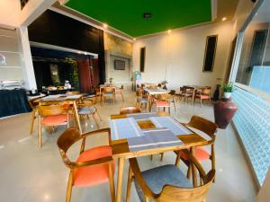 un restaurante con mesas y sillas y techo verde en Green Hayaq Hotel, en Selong