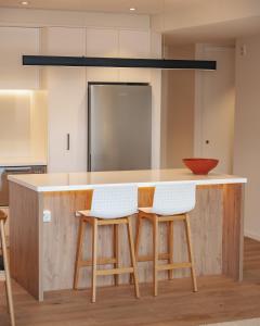 una cocina con una barra con dos taburetes en Beautiful urban apartment 4, en Nelson