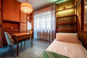 a hotel room with a desk and a bed at Vintage al Mare_ fronte spiaggia in Porto SantʼElpidio