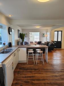 a kitchen and living room with a counter and stools at Beautiful haven near airport! in Christchurch