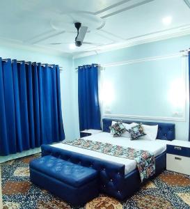 um quarto com uma cama grande e cortinas azuis em Waneposh Residency em Srinagar
