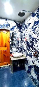 uma casa de banho azul e branca com um lavatório em Waneposh Residency em Srinagar