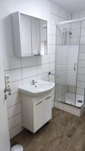 a white bathroom with a sink and a shower at FeWo Alsfeld / Vogelsberg 1 mit extra Eingang in Alsfeld