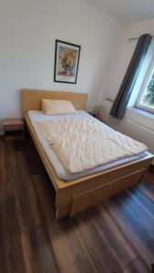 a bed in a bedroom with a wooden floor at FeWo Alsfeld / Vogelsberg 1 mit extra Eingang in Alsfeld