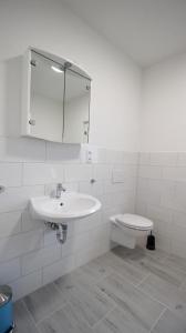 a white bathroom with a sink and a toilet at NEU! FeWo Großfelden 3 