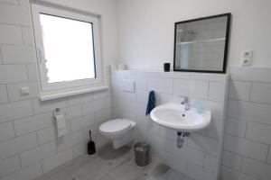 a white bathroom with a toilet and a sink at NEU! FeWo Marburg 2 mit Balkon 